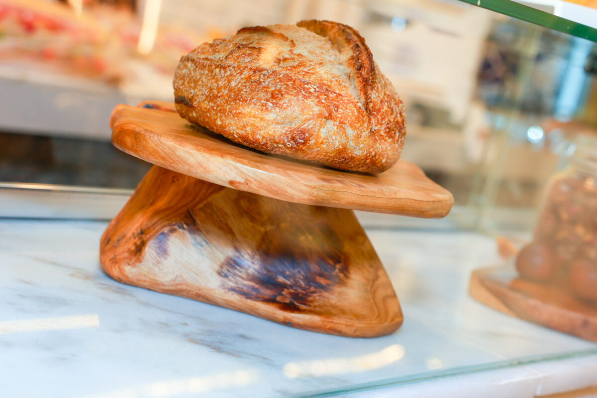 Fresh sourdough loaf on a wooden display at Farina Arena